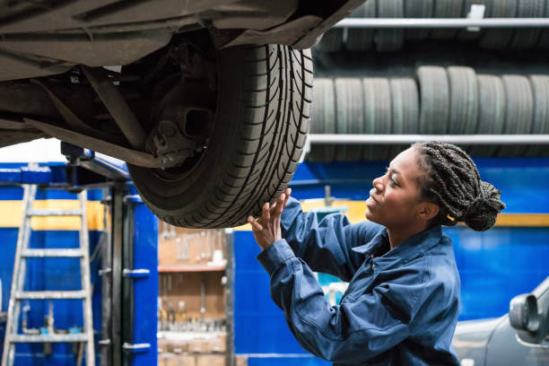 Auto mechanic inspecting a car tyre in a workshop