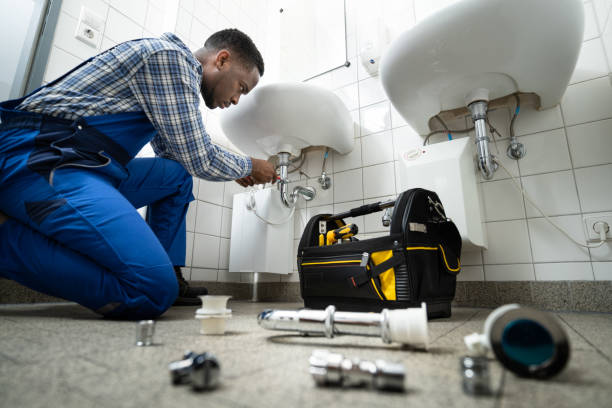 Plumber repairing a bathroom sink pipe