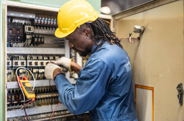 Electrician testing an industrial control panel